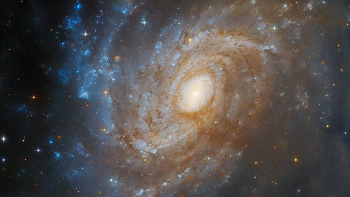 The Stunning Spiral: Hubble Captures the Intricate Beauty of Galaxy IC 4633, Hidden Within a Sea of Dust