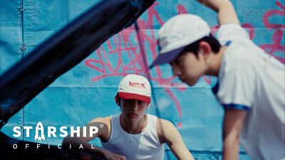 IDID 'FLY!' official music video still — K-pop group performing in a dynamic choreography scene
