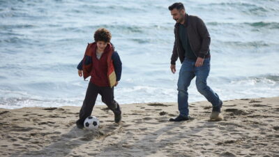 Edoardo Leo and Javier Francesco Leoni play football on a grey beach in Alessandro Aronadio's Per te