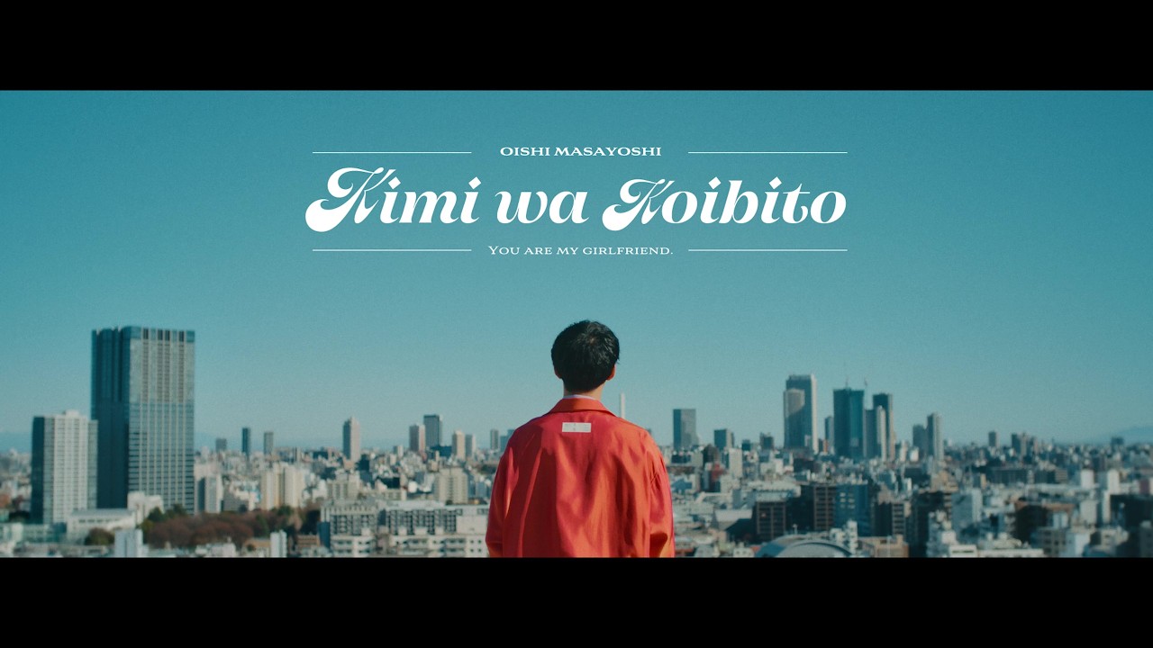 Official music video still from Masayoshi Oishi's Kimi wa Koibito, featuring two actors in a contemporary Tokyo romance
