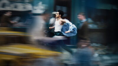 Timothee Chalamet as Marty Mauser sprints through a motion-blurred Manhattan street in Josh Safdie's Marty Supreme