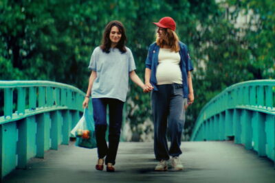 Céline (Ella Rumpf) and a pregnant Nadia (Monia Chokri) hold hands on a footbridge in Alice Douard's Love Letters.