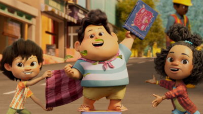 Don lifts his inherited storybook in a street scene from Ryan Adriandhy's animated film Jumbo