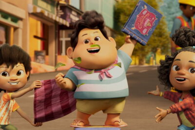 Don lifts his inherited storybook in a street scene from Ryan Adriandhy's animated film Jumbo