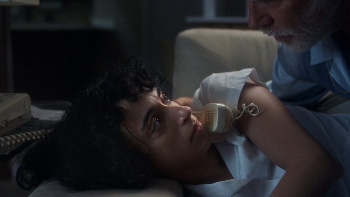 Cemre Paksoy as nurse Eleni beside her elderly patient in Night Nurse (2026)