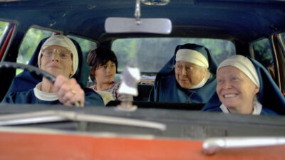 Judy Davis, Miriam Margolyes and Jacki Weaver as three nuns crammed into a car with young Brian in Nathalie Boltt's Holy Days
