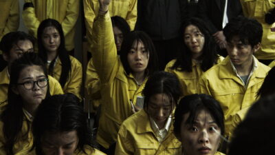 A crowd of grimy workers in yellow uniforms — the exploited Omega labour force in Park Sye-young's dystopian film The Fin.