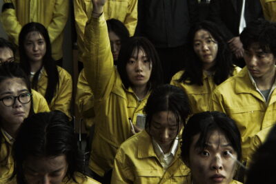 A crowd of grimy workers in yellow uniforms — the exploited Omega labour force in Park Sye-young's dystopian film The Fin.