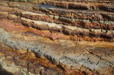 Layered sedimentary rock strata at a coastal outcrop, showing Earth's geological record of ancient climate change