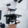A researcher adjusts a laboratory microscope in a medical research setting
