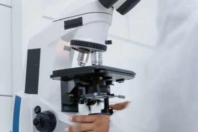 A researcher adjusts a laboratory microscope in a medical research setting