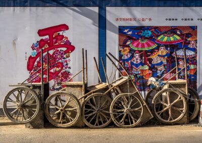 Workers carrying goods on wheelbarrows on a Beijing street in China