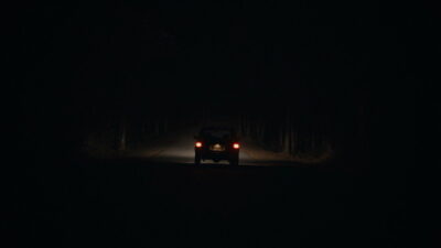 A lone SUV on a dark, endless two-lane road in Alexander Ullom's horror film It Ends