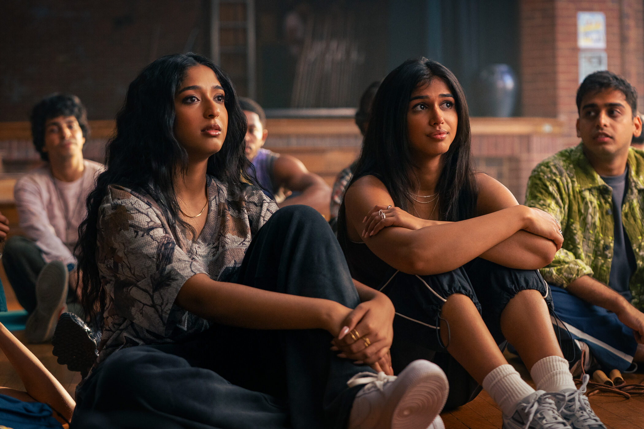 Maitreyi Ramakrishnan as Maya and Priyanka Kedia as Anjali sit with the dance team in Best of the Best