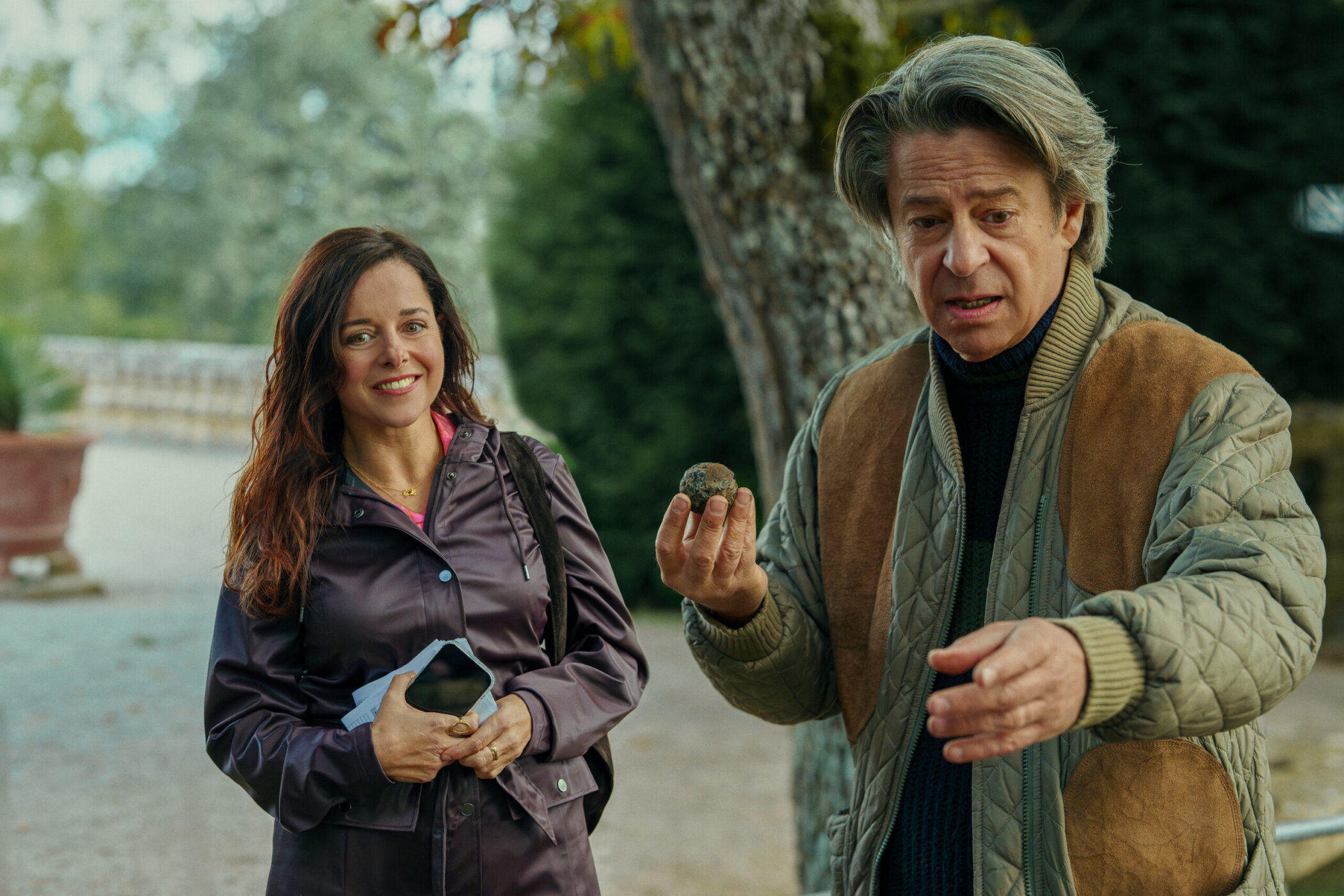Two characters talking outdoors, one holding a small ball, in Call My Agent! The Movie