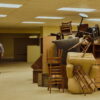 Chiwetel Ejiofor stands in the yellow-lit Backrooms, facing a pile of furniture