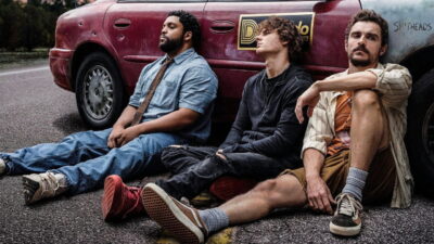 The three leads of Macon Blair's Idiots slumped against a battered van in a production still