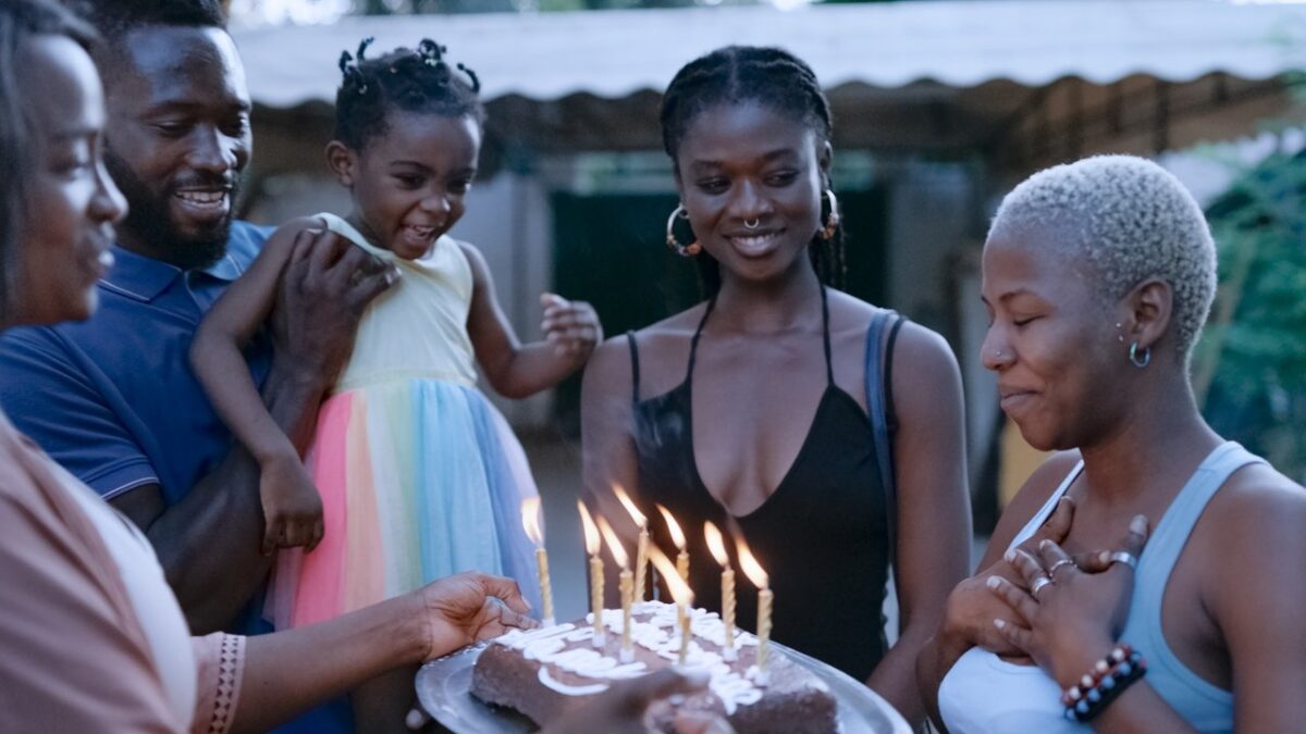 Characters gather around a birthday cake in the Erige Sehiri drama Promised Sky (2025)