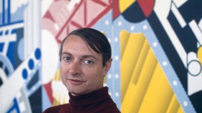 Roy Lichtenstein photographed in 1969 in front of one of his paintings