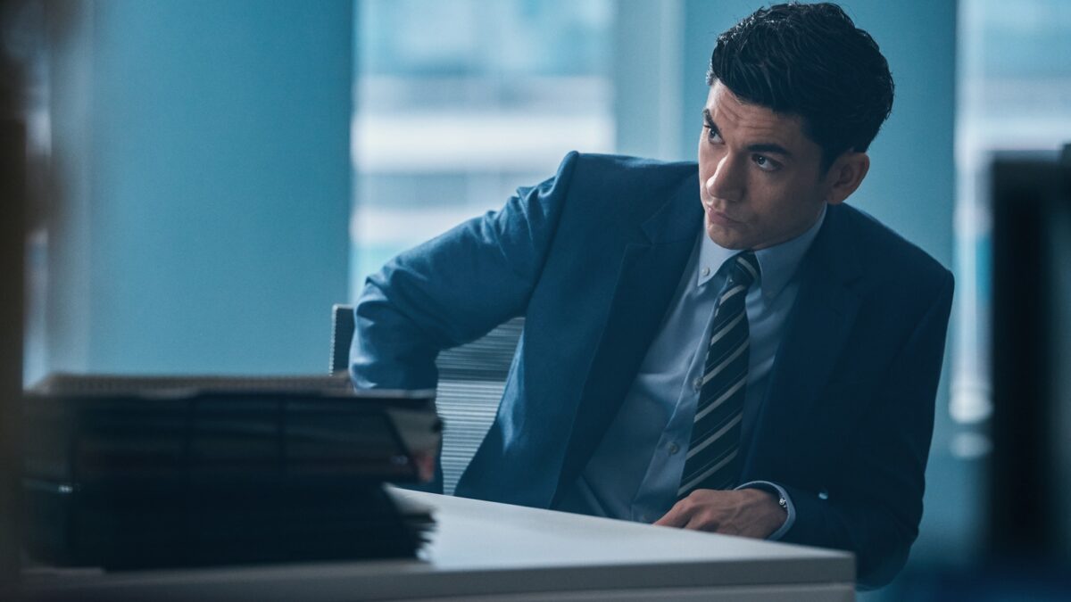Archie Renaux as lawyer Johnny Warren at his desk surrounded by case files in WAR (HBO)