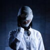 A woman with her face wrapped in bandages in key art for the Japanese series Deep Revenge
