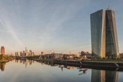 ECB headquarters twin-tower skyscraper with Frankfurt skyline at dawn, east-facing view — the Seat of the European Central Bank