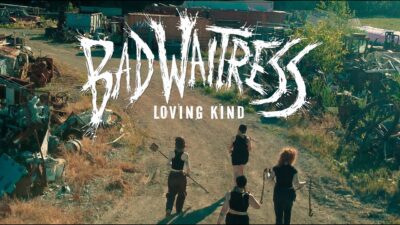Bad Waitress walking through a scrapyard in the Lovin Kind video