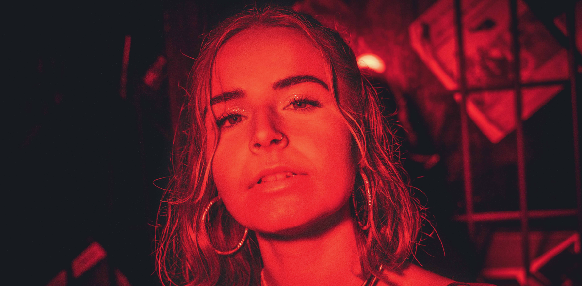 Carmie under red stage lighting, promotional photo