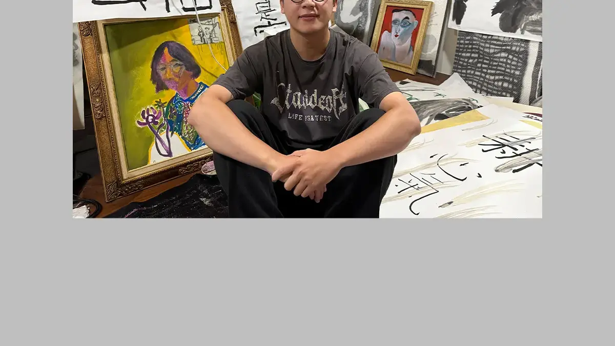 Chiu Wei-Hsiang seated in his studio surrounded by paintings and calligraphy works in progress