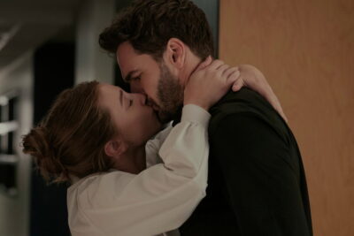 Lili Reinhart and Tom Bateman kiss in an academic hallway in The Love Hypothesis