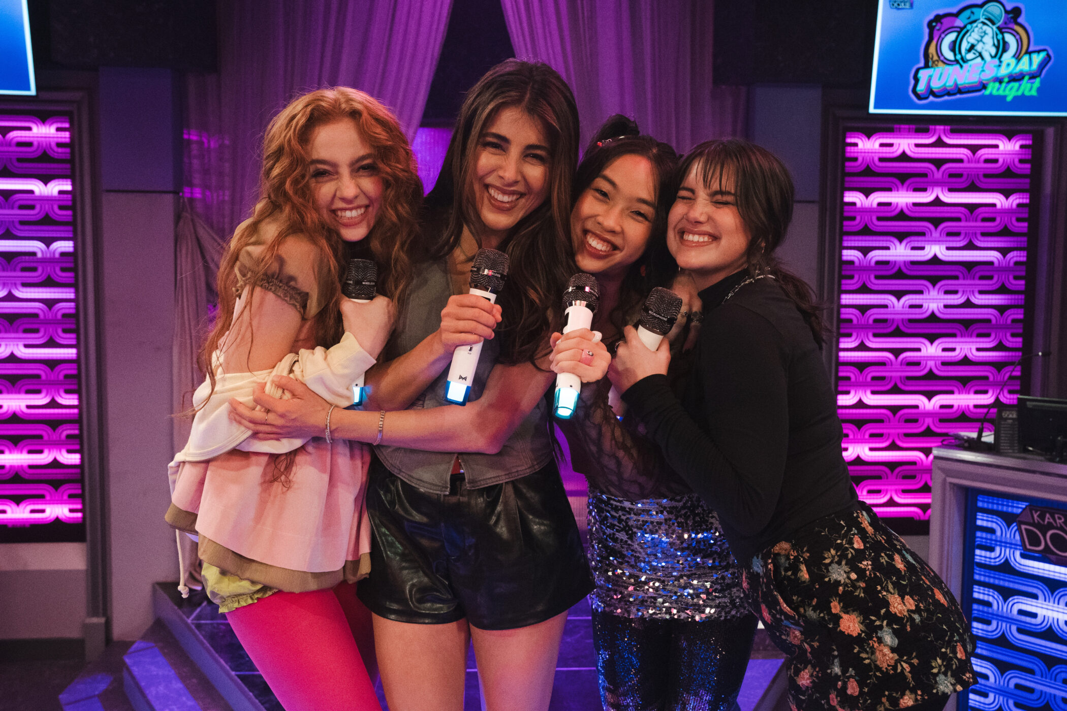 Four students laughing with microphones on the Tunesday Night set in Hollywood Arts