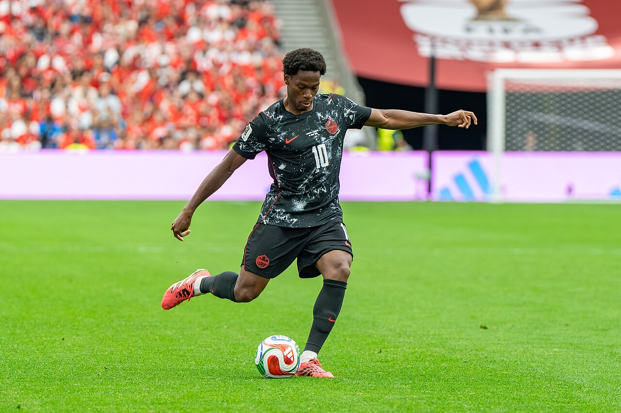 Jonathan David controls the ball in a Canada shirt