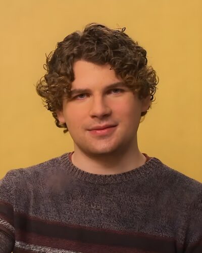 Kane Parsons, director of Backrooms, smiling during a 2026 interview in front of a yellow backdrop