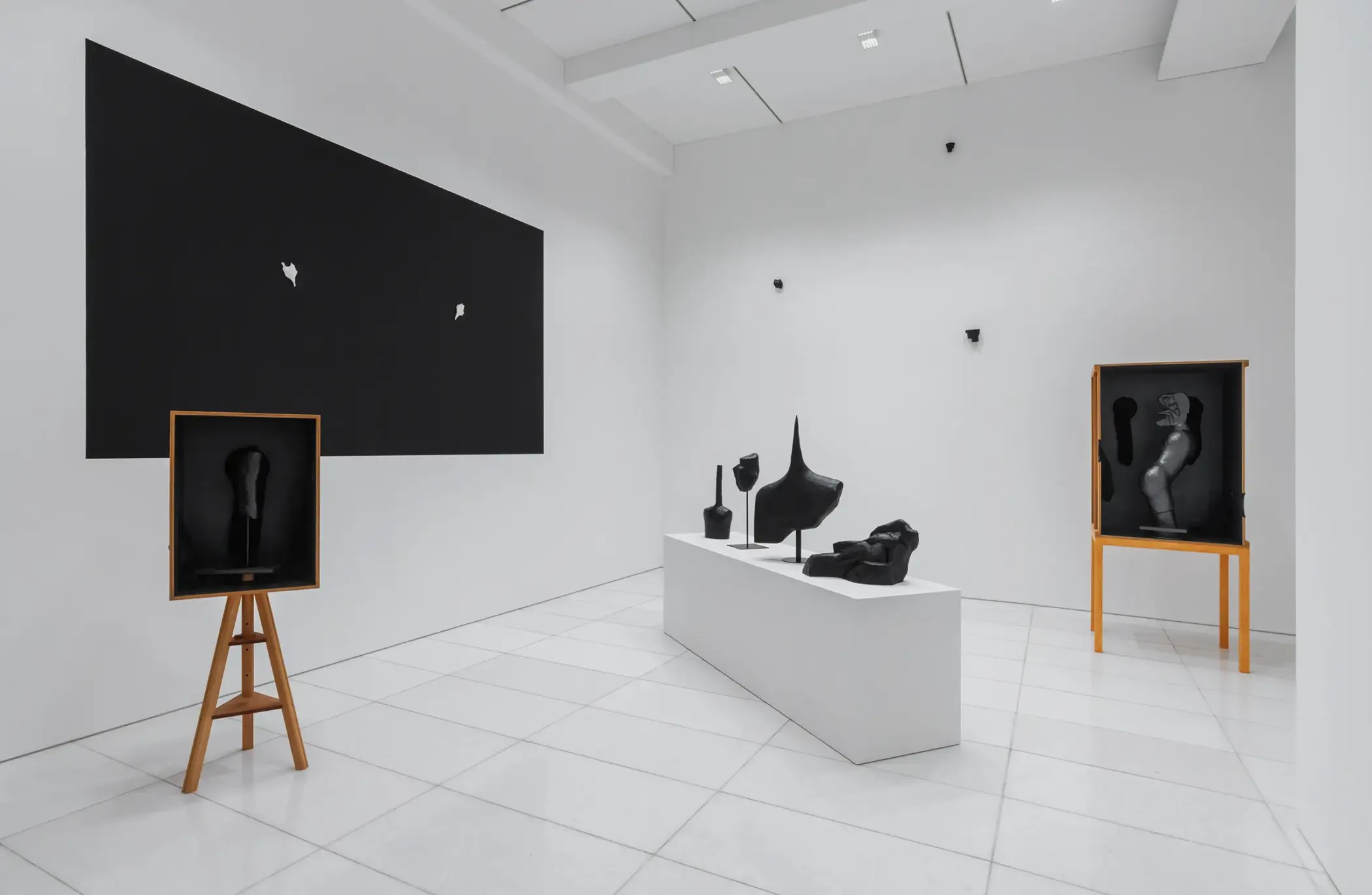 Installation view of KIM Inbai A Man Asleep at Arario Gallery Seoul showing dark sculptures and wooden boxes with blind tactile sculptures