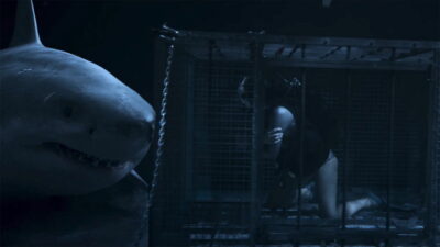 A great white shark circles a diver trapped in a submerged cage in Jesse V. Johnson's Above & Below.