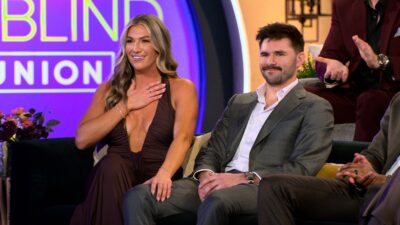 Love Is Blind season 10 couple smiling on the couch at the Ohio reunion on Netflix