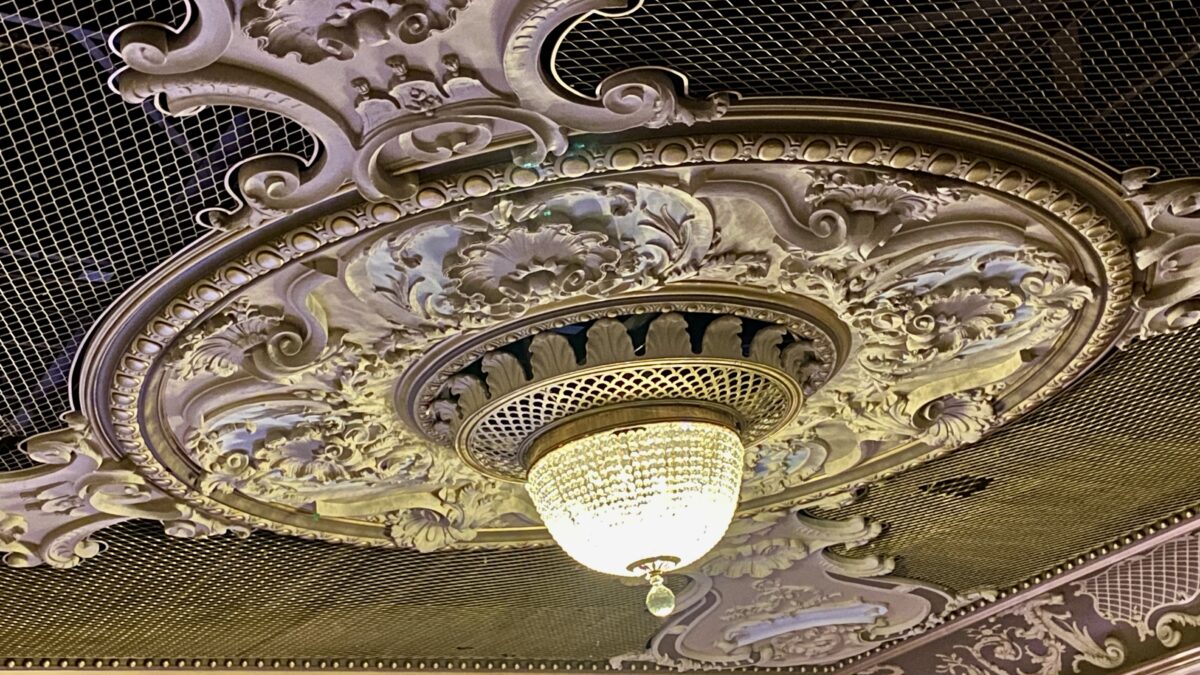 Ornate plaster ceiling rose and crystal chandelier inside the Lyric Hammersmith Theatre auditorium