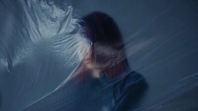 Jane Remover seen through a sheet of plastic in a still from the Beauty Sleep music video