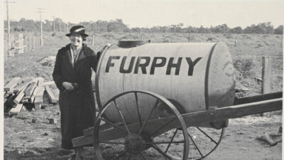 Miles Franklin standing beside a Furphy water cart in 1938