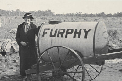 Miles Franklin standing beside a Furphy water cart in 1938