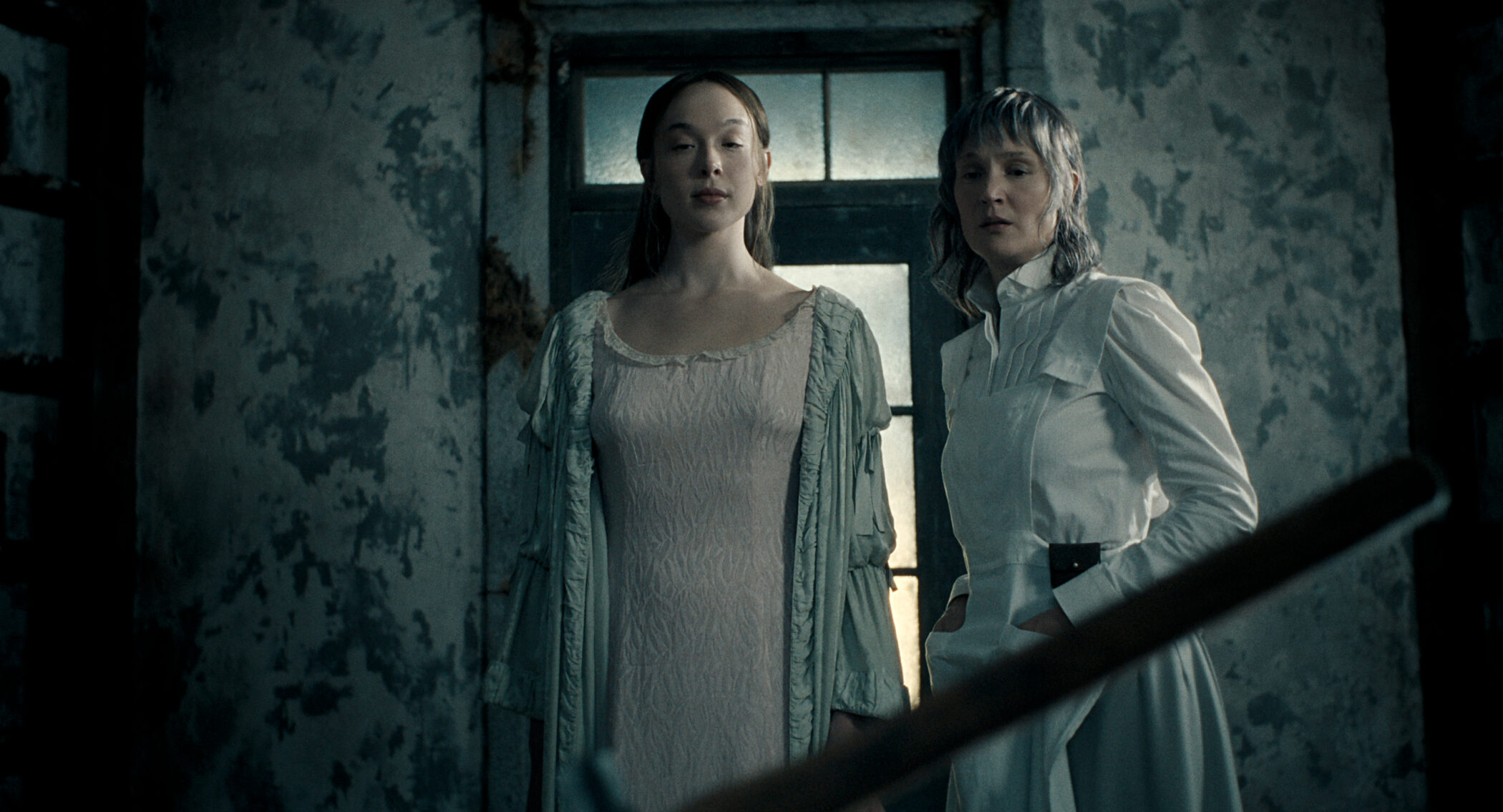Two women in period dress in a decaying room in Monster: The Lizzie Borden Story