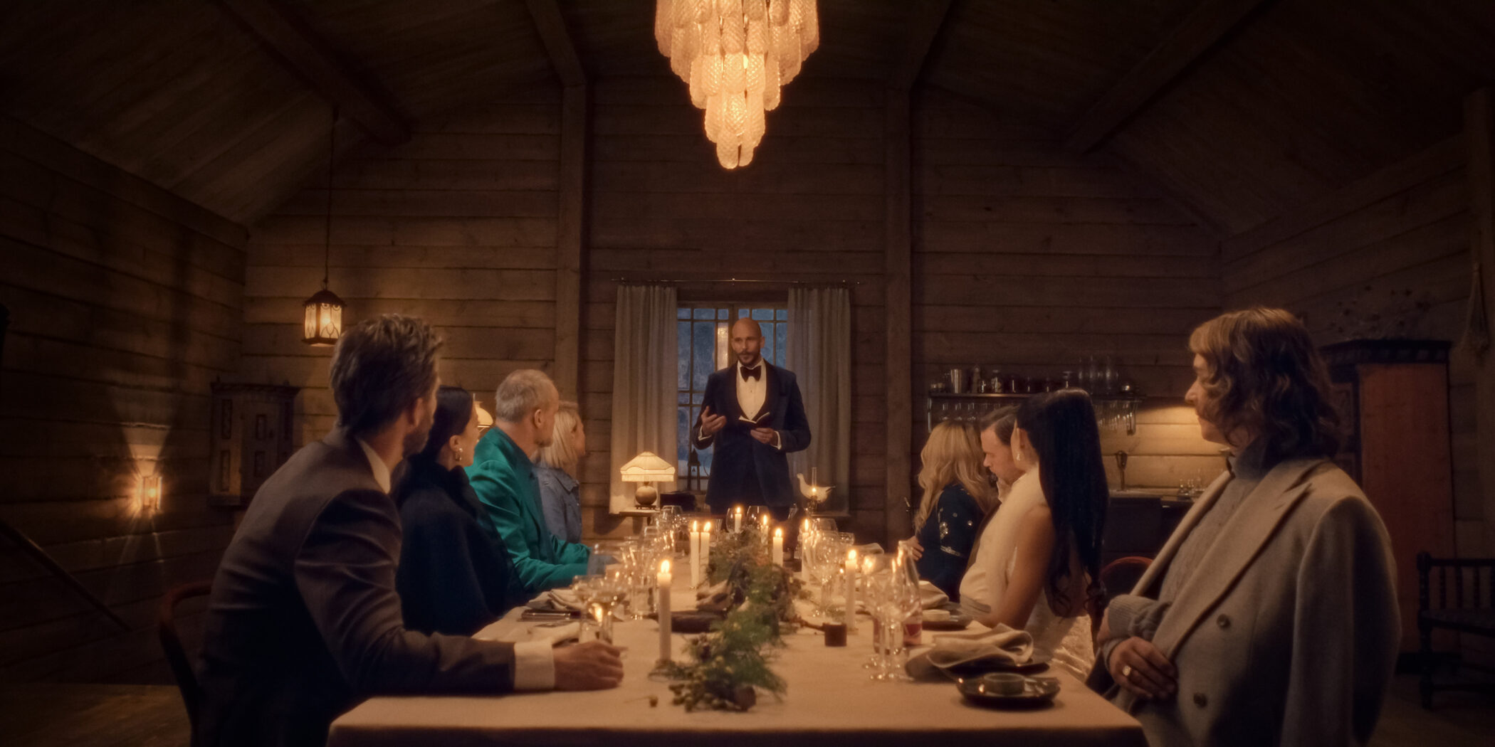Guests around a candlelit dinner table at the farm in The Storm