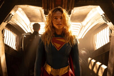 Milly Alcock as Supergirl standing in a dramatically lit corridor in DC Studios film