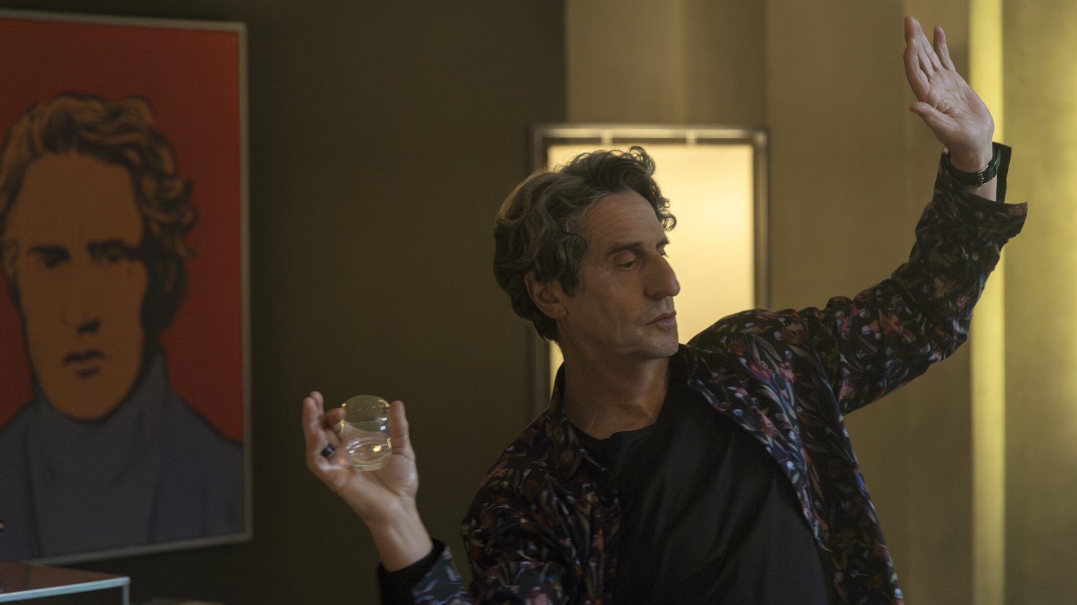 Diego Peretti raising his hand while holding a glass in the Netflix film Therapy Done Right