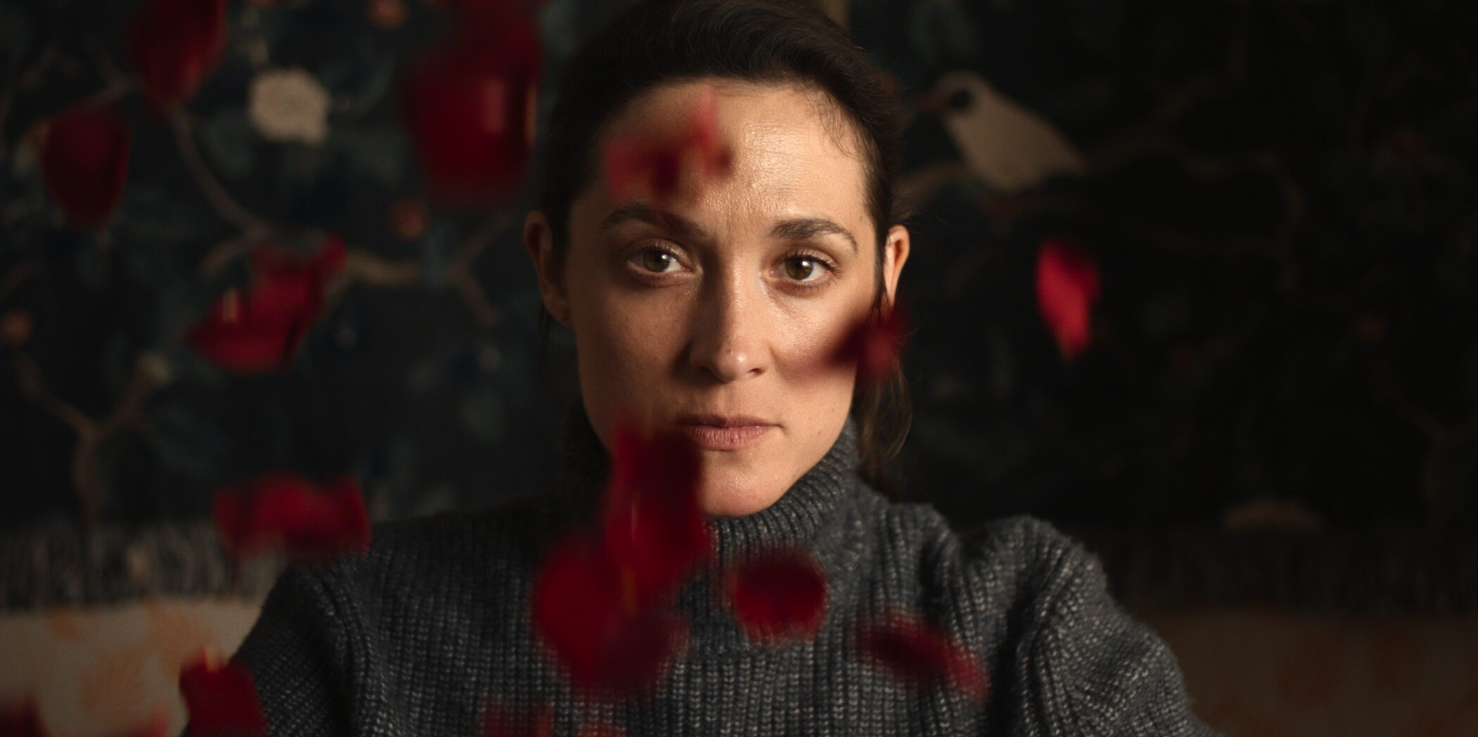 A woman seen through blood-spattered glass in The Trap