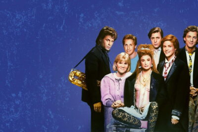 The cast of St. Elmo's Fire, with Rob Lowe holding a saxophone, in the 1985 film's key art