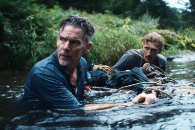 Ethan Hawke wades through a river in Padraic McKinley's prison thriller The Weight