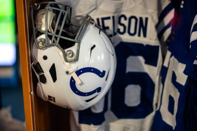 A white Indianapolis Colts helmet hanging in a locker in front of Quenton Nelson's white number 56 jersey, with a blue number 56 jersey beside it, 2021