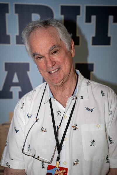 John Pomeroy, white-haired and smiling, in a Mickey Mouse print shirt with glasses on a lanyard at the Animation Y'all festival at Lipscomb University, April 2026
