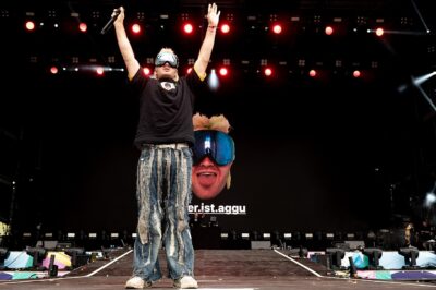Ski Aggu in his trademark ski goggles, arms raised on stage at Superbloom Festival in Munich